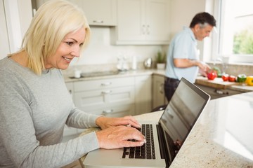 Obraz premium Happy mature blonde using laptop