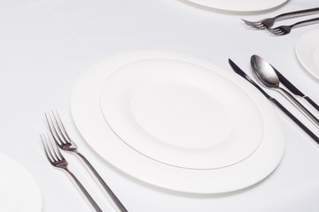 Plates, forks, spoons on table in restaurant