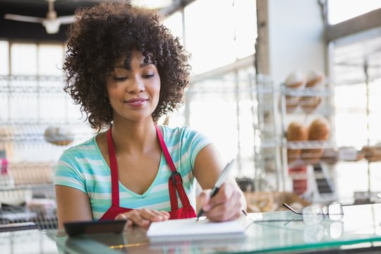 Smiling waitress writing on notepad