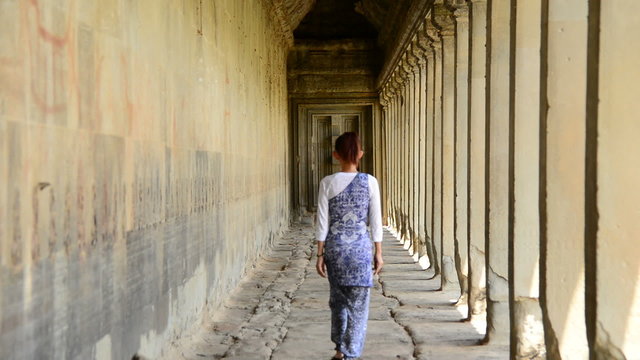 Female Buddhist Slowly Walking Down Temple Hallway  - Angkor Wat Temple Cambodia