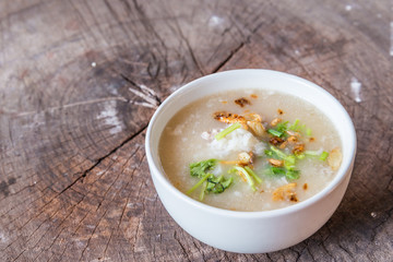 Bowl of oats porridge on wooden table. Healthy breakfast