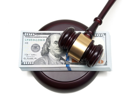 big wad of money and gavel closeup isolated on a white backgroun
