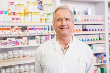 Smiling senior pharmacist standing