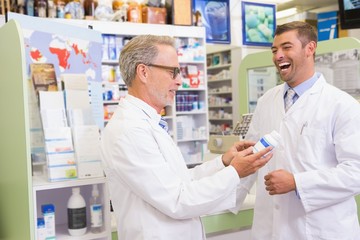 Smiling pharmacists holding medication