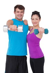 Fit man and woman lifting dumbbells