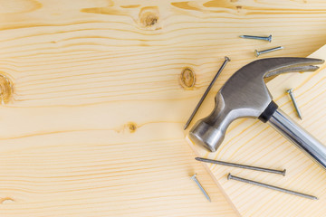 Hammer and nails on a wooden background