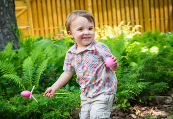 Little Boy Smiles Holding Pink Easter Eggs