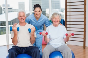 Happy female instructor with arms around senior couple