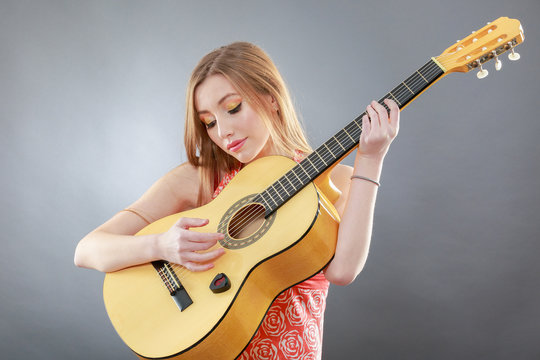 a beautiful young blonde with a classical guitar