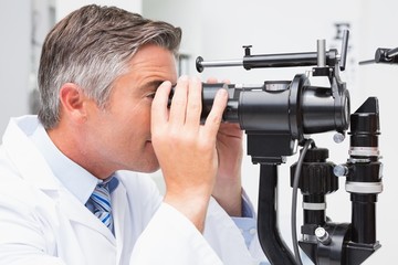 Optometrist looking in optical instrument