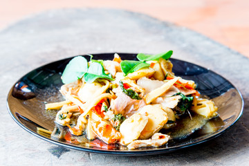 Basil fried pork in black plate.