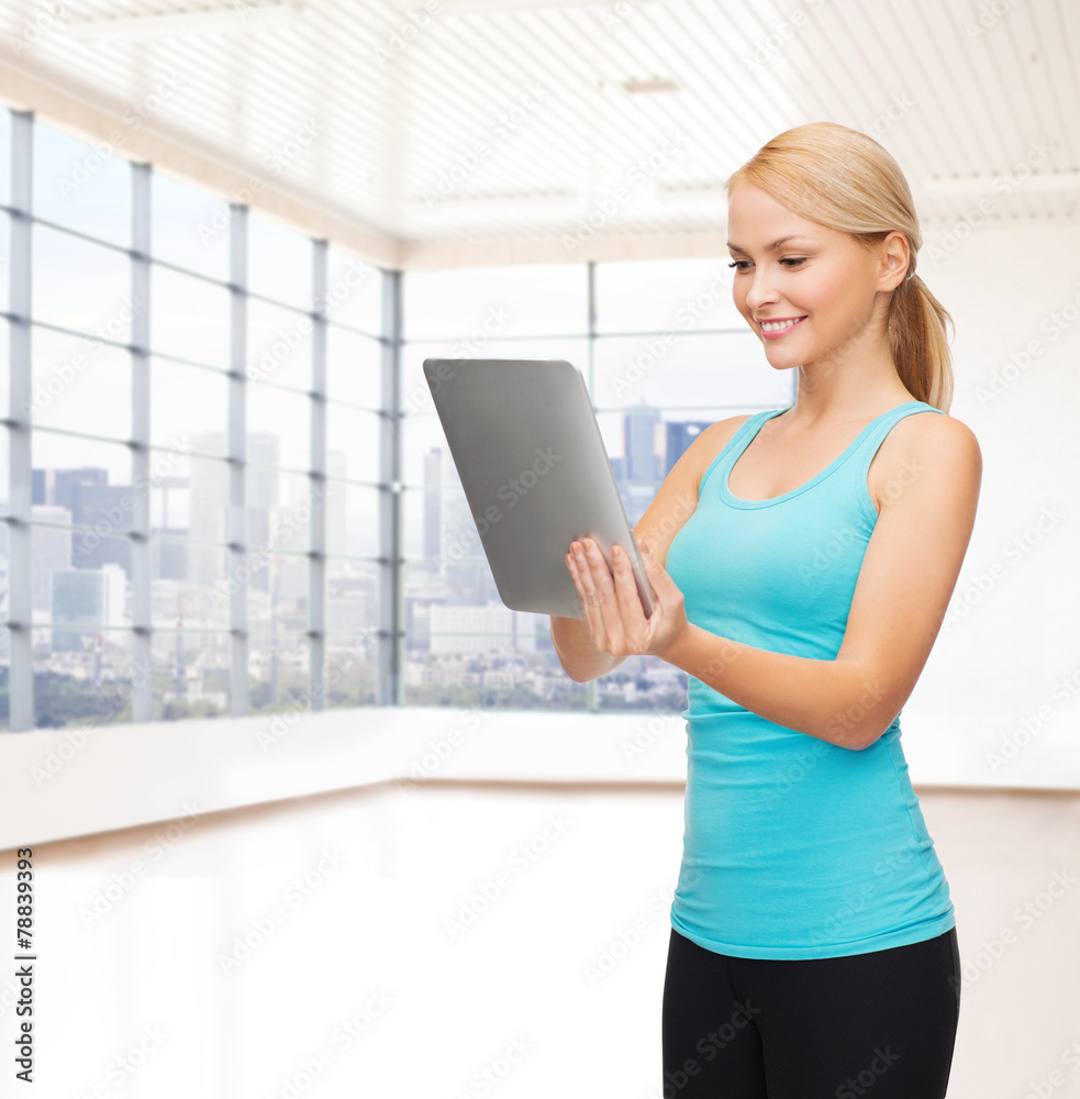 Poster smiling woman with tablet pc in gym