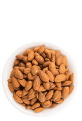Raw almond nut in a white bowl over white background