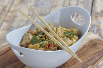 Bowl with asian noodles chicken and chopsticks