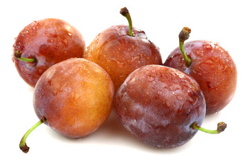 five fresh ripe plums on a white background