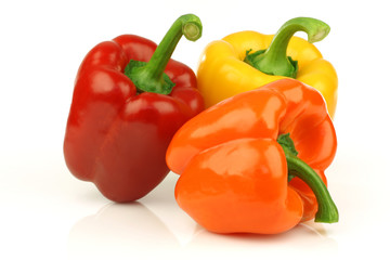 red, orange and yellow bell pepper(capsicum) on a white backgrou