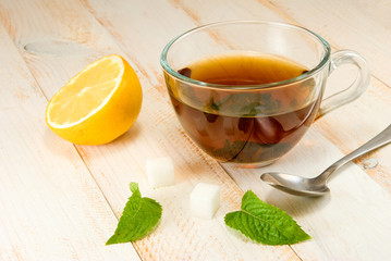 cup of tea with lemon and mint on a wooden table