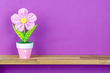 An artificial potted plant on a shelf with copy space background