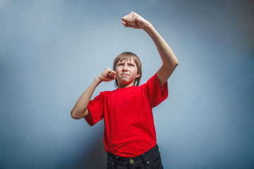 Boy, teenager, twelve years  red  in shirt, showing his fists