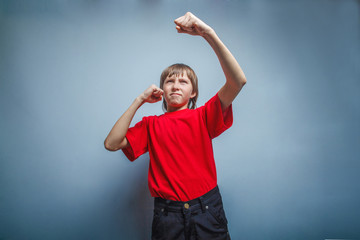 Boy, teenager, twelve years in  red shirt, showing his fists