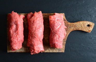 Beef rolls on a wooden board