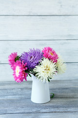 Beautiful asters in a vase on the boards