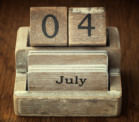 A very old wooden vintage calendar showing the date 4th July on