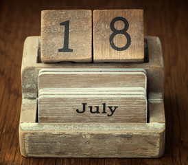 A very old wooden vintage calendar showing the date 18th July on