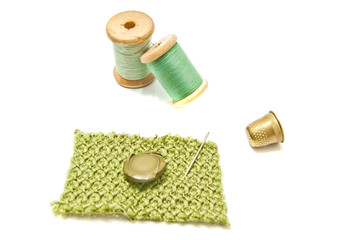 spools of green thread, button and thimble