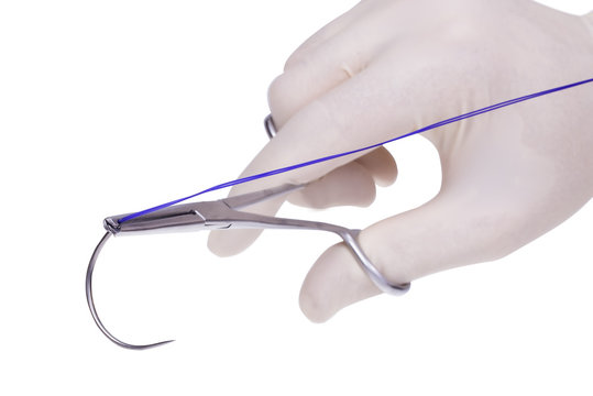 steel surgical  forceps  holding a suture needle