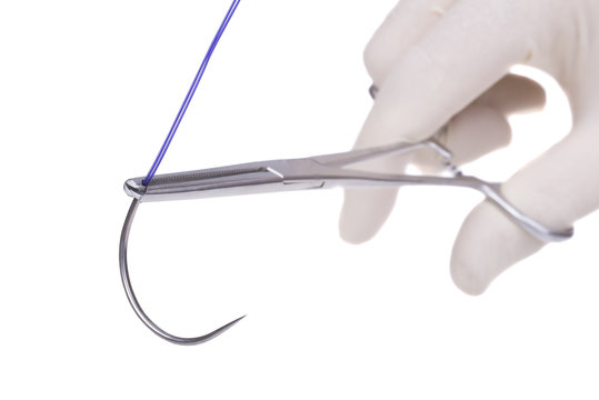 steel surgical  forceps  holding a suture needle
