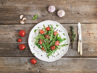 Salad with arugula, cherry tomatoes, sunflower seeds and herbs