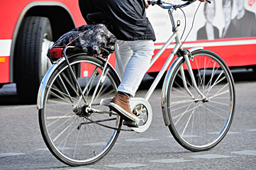 Fototapeta premium Bicyclist in traffic, bus in background