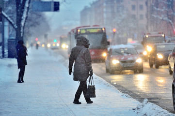 Commuters waiting for arriving bus in snowstorm