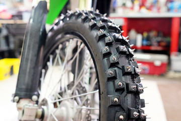 Closeup detail of a motorcycle front wheel with metall spikes