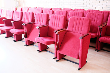 Large red recliners stand rows in an empty hall