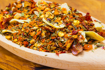 Colored spices for pasta mix on wooden spoon
