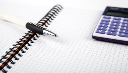 pen on a notebook into a cell and calculator