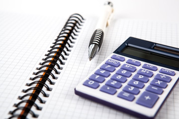 pen on a notebook into a cell and calculator