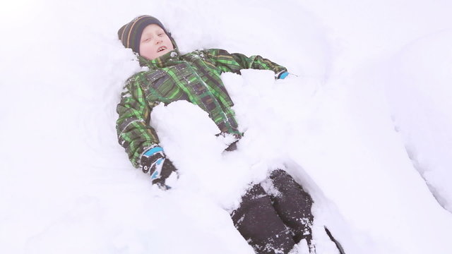 Little boy smiling and doing Snow angel