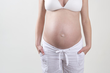 Pregnant woman in front of a white background