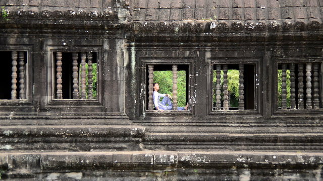 Female Buddhist Meditating in Temple Window - Angkor Wat, Cambodia