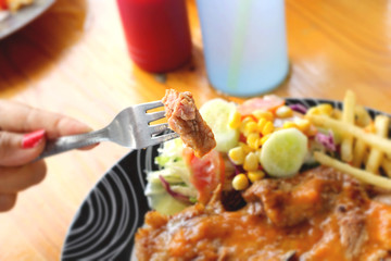 Steaks, french fries with vegetables salad on a plate.