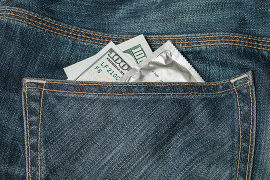 US dollars and condom in the jeans pocket