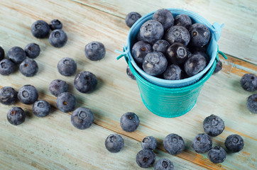 Blueberries in  small buckets on  wooden table.
