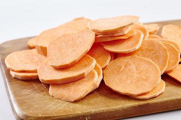 Chopped sweet potatoes on wooden board