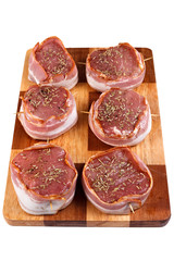 Steak with bacon and spices prepared for grilling. Isolated