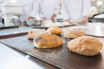 Co-workers making bagels and bread together