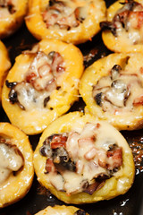 Baked potatoes with mushrooms, meat and cheese.