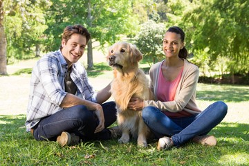 Happy couple with their dog in the park